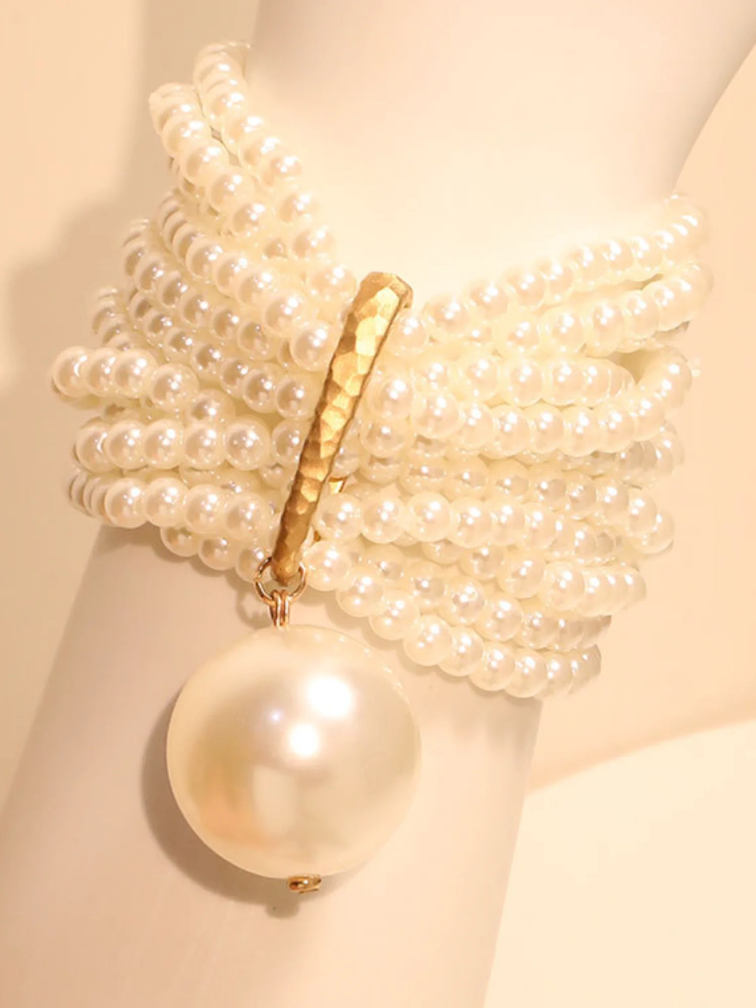 Multi-layered beaded artificial crystal bracelet with large pearl pendant.