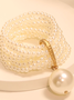 Multi-layered beaded artificial crystal bracelet with large pearl pendant.
